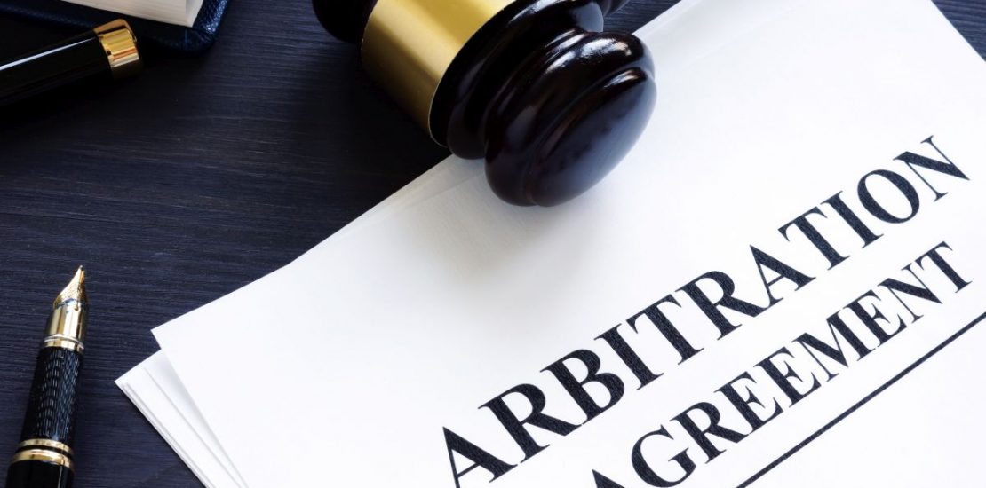 Arbitration agreement and gavel on a desk.
